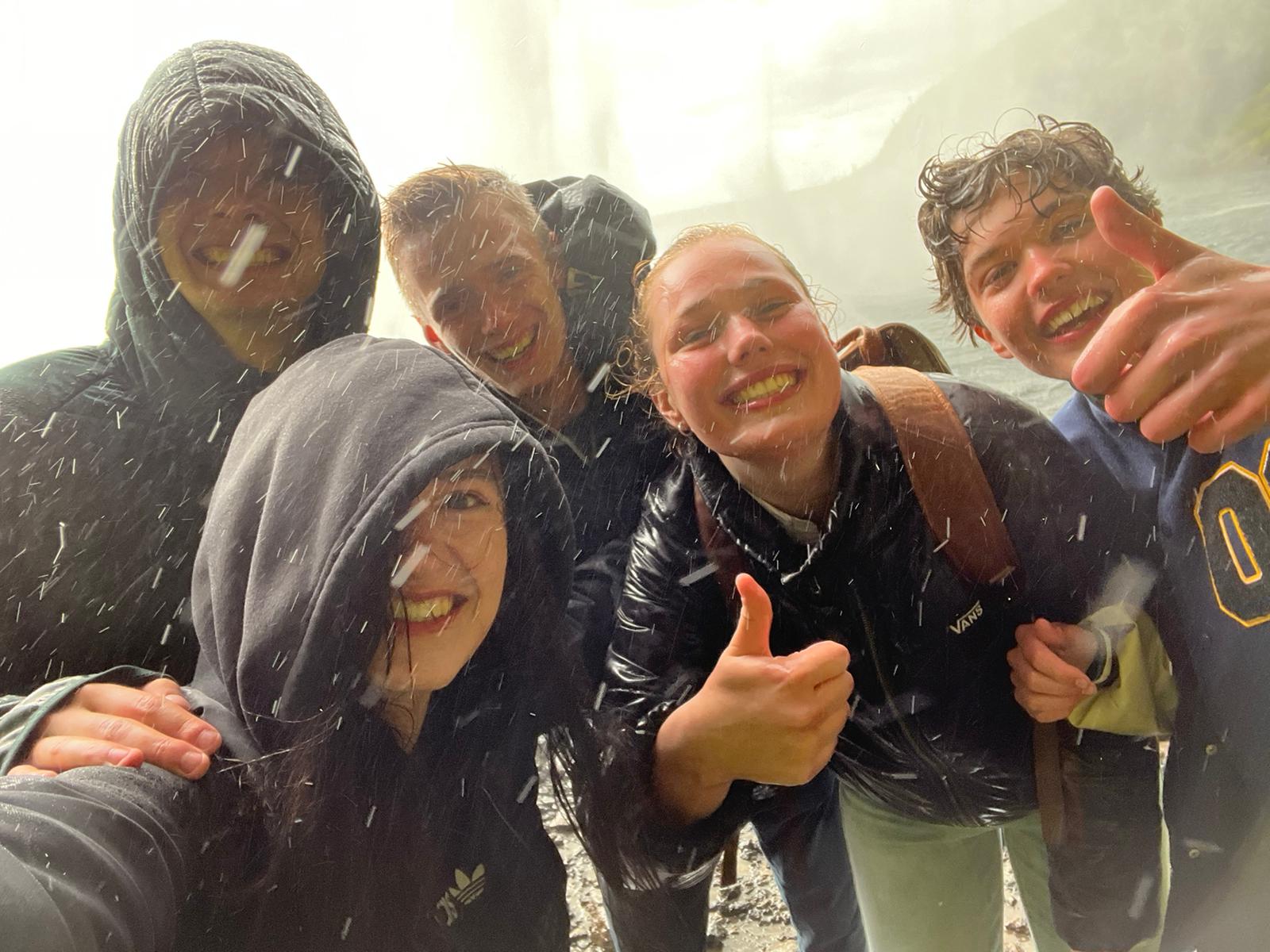 Deelnemers bij de waterval in IJsland